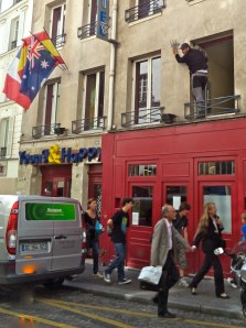This guy leaning out of a second-floor window is installing flag holders for Young and Happy, a youth hostel.