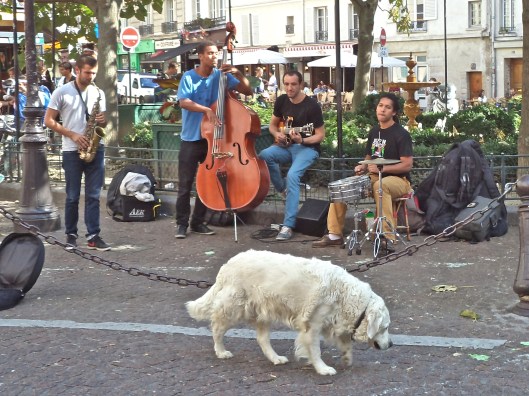 There is plenty of room for performers and pets on the Place Contrescarpe.  Usually the square is crowded, but this week the tourists are gone.  So there are plenty of chairs in the cafés, and you can hear the music and the splashing of the fountain.